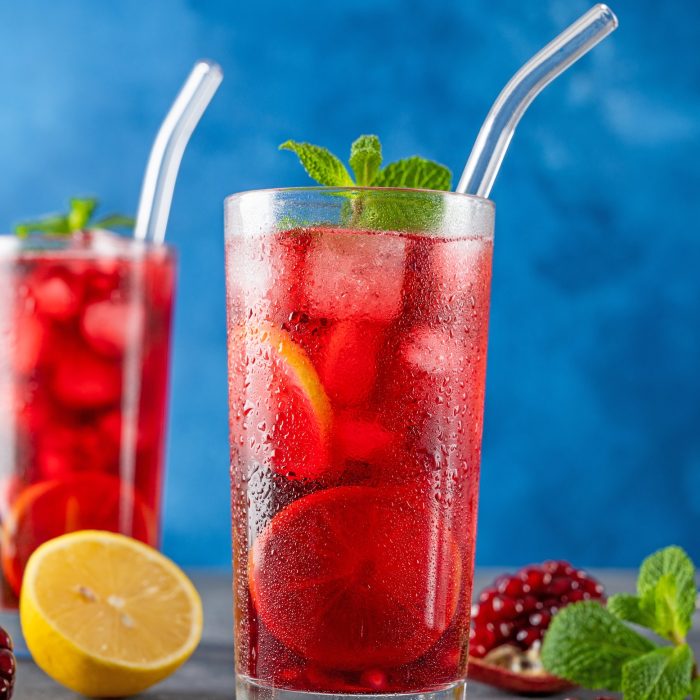 Summer drink. Red lemonade with pomegranate, cold hibiscus with lemon and mint in a glass.